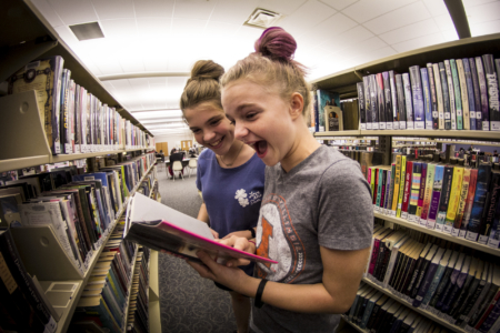 Young Adult patrons find an exciting book in the downstairs YA section